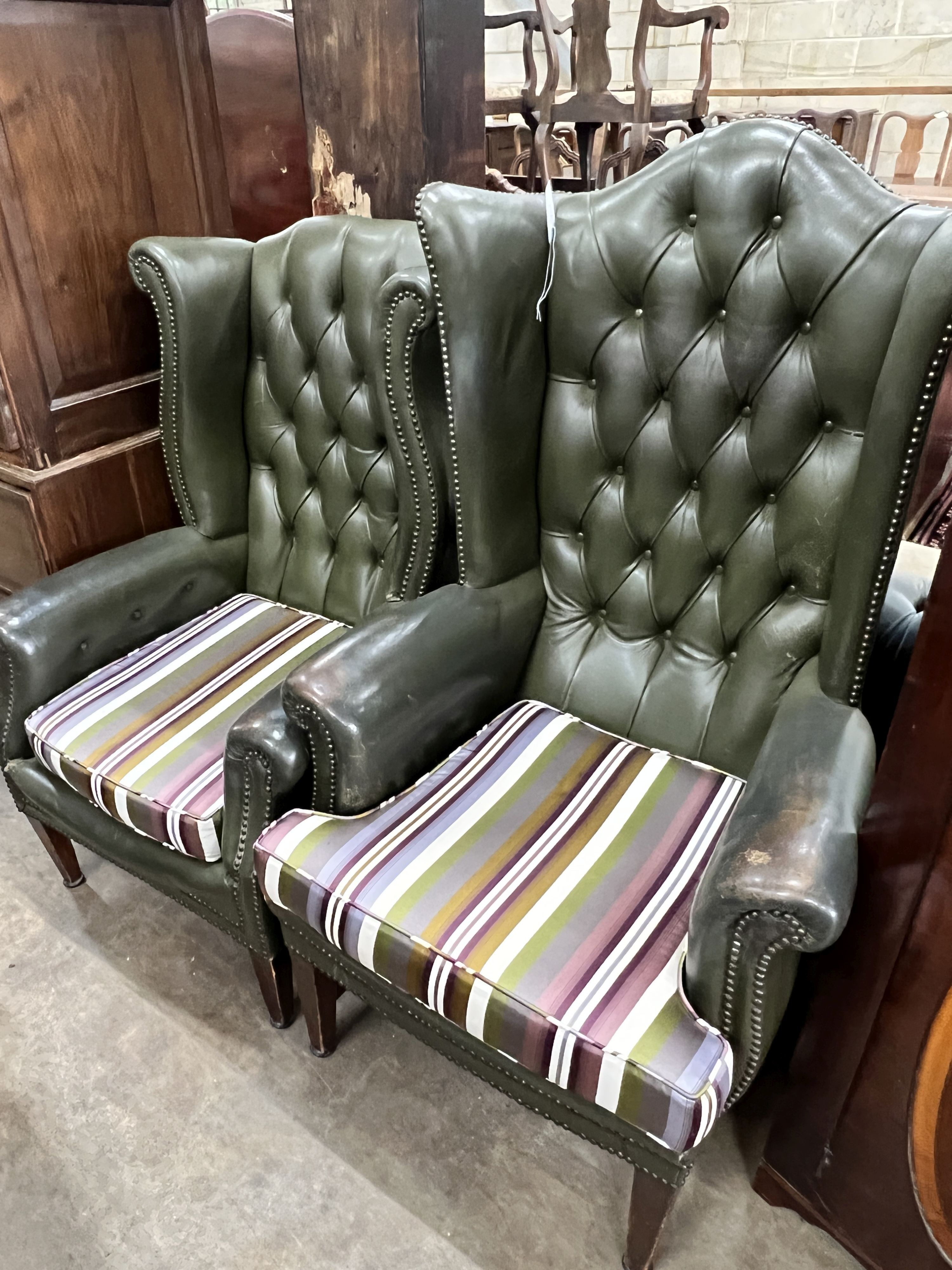 Two Victorian style buttoned green leather wing armchairs